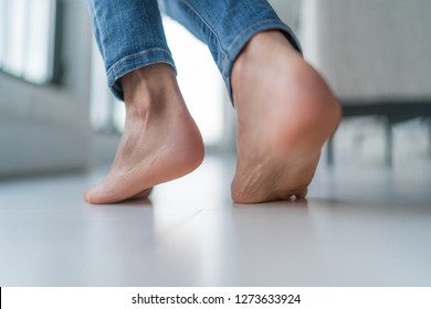 Floor Heating Woman Walking Barefoot On Hardwood Floor In Winter Inside Home. Comfort Living Room Lifestyle. Closeup Of Women Feet.