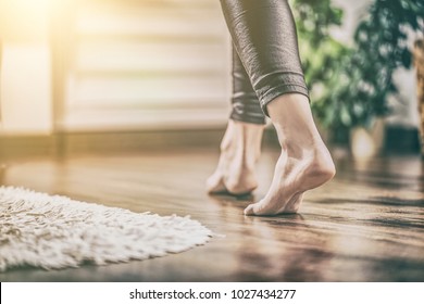 Floor heating. Young woman walking in the house on the warm floor. Gently walked the wooden panels. - Shutterstock ID 1027434277