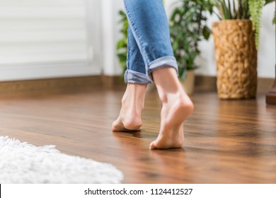 Floor heating. Young woman walking in the house on the warm floor. Gently walked the wooden panels. - Shutterstock ID 1124412527
