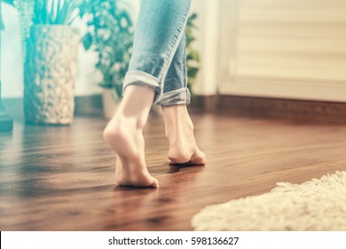 Floor heating. Young woman walking in the house on the warm floor. Gently walked the wooden panels. - Shutterstock ID 598136627