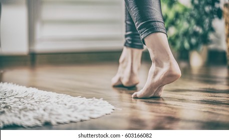 Floor Heating. Young Woman Walking In The House On The Warm Floor. Gently Walked The Wooden Panels.