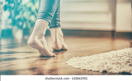 Floor heating. Young woman walking in the house on the warm floor. Gently walked the wooden panels. - Shutterstock ID 618061901