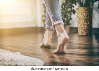 Floor heating. Young woman walking in the house on the warm floor. Gently walked the wooden panels. - Shutterstock ID 626435741