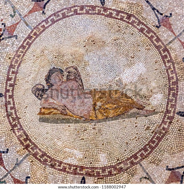 Floor mosaic of colored stones with the god of sleep Hypnos - young man with wings, lying on pillow, museum "Roman mosaics", Risana, Boca-kotor bay, Montenegro