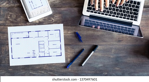 Floor plan drawing with architect designing home on computer, old wooden desk with blueprint of house or apartment project