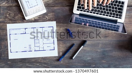 Floor plan drawing with architect designing home on computer, old wooden desk with blueprint of house or apartment project