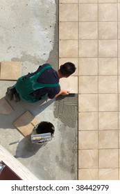 Floor Tiles Installation. Man Installs Ceramic Tile