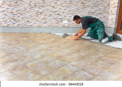 Floor Tiles Installation. Man Installs Ceramic Tile