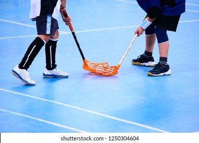 Floorball child boy player with stick and ball. Children playing florball sport. Floor in the sports hall designed for sports