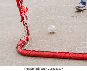 Floorball goal ready for training. Children playing outdoor in spring. Floor hockey players goalkeeper running with ball and sticks. Outside leisure, active lifestyle kids sport.