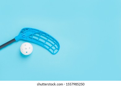 Floorball stick and white ball isolated on blue background