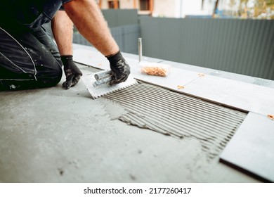 Flooring And Tiling. Professional Tiler Placing Floor Tiles On Adhesive Surface On Balcony