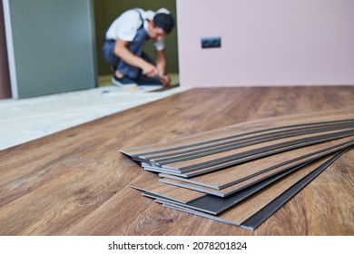 Flooring work. worker joining vinyl floor covering at home renovation