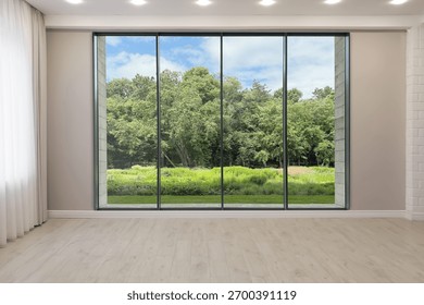 Floor-to-ceiling window with garden view in empty spacious room. Interior design