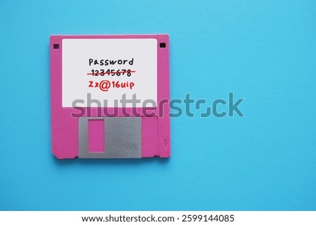 Floppy disk on blue background with very weak and easy to guess password written - replaced to strong and more secure password
