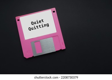 Floppy Disk On Copy Space Black Background With Text On Tag QUIET QUITTING, Diminished Motivation And Low Engagement Gen Z Employees, Doing Only What Job Demands And Nothing More