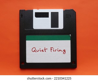 Floppy Disk On Orange Background With Handwritten Text QUIET FIRING - Employer Creating A Hostile Work Environment In The Hopes That It Will Cause An Employee To Quit