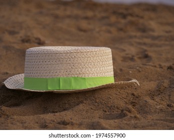 Floppy Straw Hat Left  In The Sand Close Up Shot