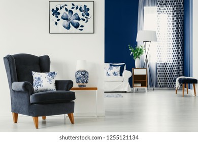 Floral accents in bright living room interior in blue and white colors, real photo
