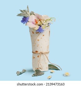 floral arrangement. a bouquet of flowers wrapped in a tortilla. creative concept. blue background. - Powered by Shutterstock