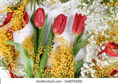 Floral background, spring concept, white wooden board, red ribbon, srping flowers like gypsophila, yellow Mimosa Pudica. Space for text, copy space in the center, middle empty