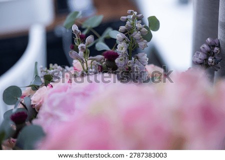 Floral composition includes pink roses and purple blooms with eucalyptus leaves, arranged in a soft-focus environment, enhancing the visual appeal of the flowers