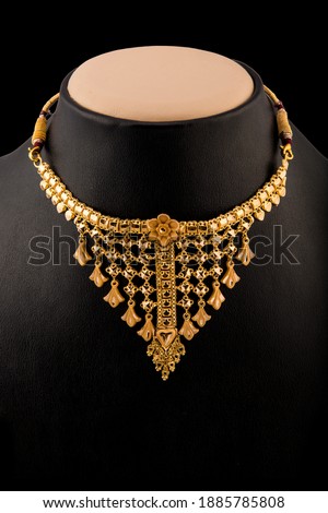 Floral design cool gold neckless isolated on black background.