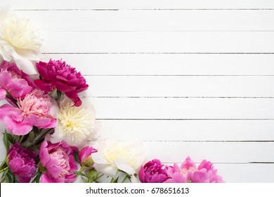 Floral frame / background with beautiful pink, purple and white peonies on old white wooden background. Shabby chic, vintage flowers for wedding, Happy Mother's day or Women's day
