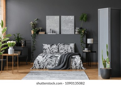 Floral Pattern Black Bedding In A Stylish, Dark Gray Bedroom Interior With Plants And Elegant Furniture