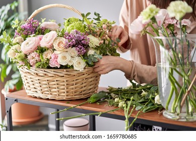 Floral shop concept . Florist woman creates flower arrangement in a wicker basket. Beautiful bouquet of mixed flowers. Handsome fresh bunch. Flowers delivery. - Powered by Shutterstock