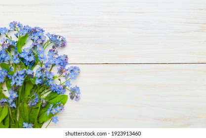 Floral Spring Template For Design With Bouquet Of Blue Forget-me-nots Flowers On White Wood Background. Top View. Flat Lay. Beautiful Spring Web Banner With Copy Space