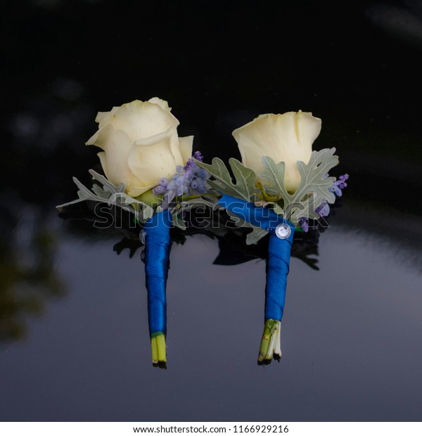 floral wedding boutonniere with blue ribbon and\
yellow roses.