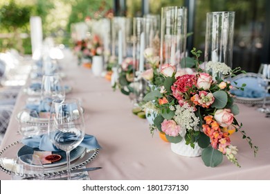 Floral wedding decoration. Wedding table setting decorated with fresh flowers. Wedding floristry. Bouquet with roses, eustoma and eucalyptus leaves.