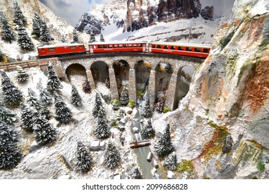 Florence, ITALY- December 2021: Model railway with Swiss Bernina express train on viaduct.