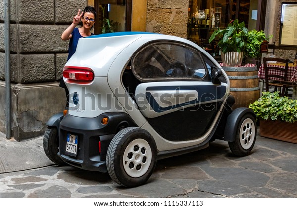 Florence, Italy - June 8, 2018: A\
woman shows off her Twizy, a small two-seat electric car designed\
and marketed by Renault and manufactured in Valladolid,\
Spain.