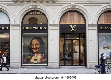Florence, Italy - May 11, 2017: People walk past Louis Vuitton store windows in Florence, Italy