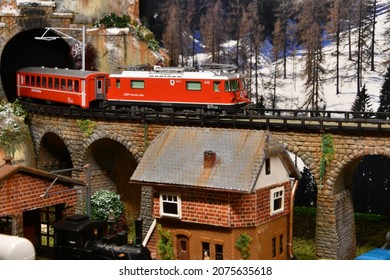 Florence, ITALY- November 2021: Railway model with Swiss Bernina Express Train on viaduct in mountains ambientation.