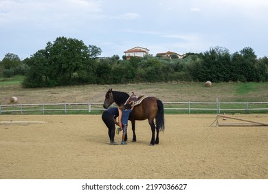 Florence, Tuscany Italy 08-26-2022. Riding Teacher Helping Her Student To Get On A Horse