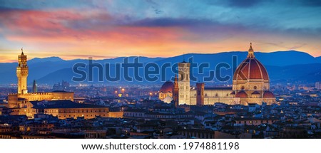 Florence, Tuscany, Italy. Panorama Sunset view at Duomo Santa Maria del Fiore cathedral and Palazzo Vecchio Tower. Panoramic View of Firenze during sunset. Scenic landscape mountains evening sky.