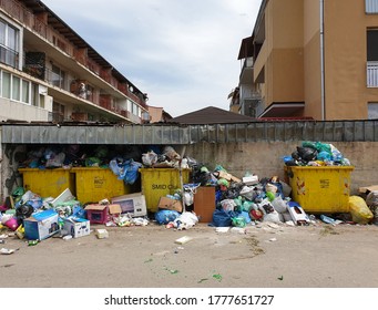 Floresti, Romania - June 07, 20202: Messy pollution in garbage dump area spills in the streets of Floresti, Cluj, Romania. Trash accumulation in the street from filled yellow bins