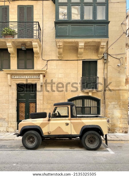 Floriana,\
Malta - October 2021: Old army offroad car in Malta Camouflage in\
the streets of Floriana, a suburb of\
Valletta