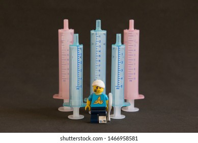 Florianopolis - Brazil, July 31, 2019: Closeup Clumsy Guy Wih His Crutches In Front Of Syringes On Black Background. Minifigures Are Manufactured By The Lego Group.