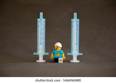 Florianopolis - Brazil, July 31, 2019: Closeup Clumsy Guy Wih His Crutches Between Syringes On Black Background. Minifigures Are Manufactured By The Lego Group.