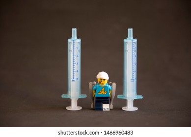 Florianopolis - Brazil, July 31, 2019: Closeup Clumsy Guy Wih His Crutches Between Syringes On Black Background. Minifigures Are Manufactured By The Lego Group.