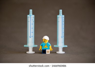 Florianopolis - Brazil, July 31, 2019: Closeup Clumsy Guy Wih His Crutches Between Syringes On Black Background. Minifigures Are Manufactured By The Lego Group.