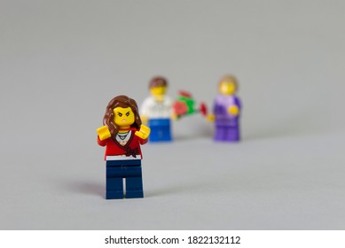 Florianopolis, Brazil. September 19, 2020: Minifigure of angry and jealous girl for her friend receiving a bouquet of flowers from a boy on white background. Selective focus. Copy space. - Shutterstock ID 1822132112