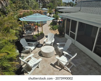 Florida Backyard With Umbrella And Adirondack Chairs Located On Gulf Boulevard Manasota Key Florida USA. September 2021