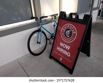 Florida, U.S.A - Circa 2021: A Chipotle sign says "Now Hiring". Amid the COVID-19 pandemic, inflation and a labor shortage, Chipotle (NYSE:CMG) raised employee pay, wages and offers worker bonuses.