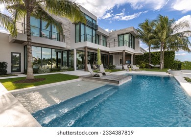Florida, USA. Modern building with swimming pool, trees, chairs. Urban landscape with blue reflecting pool, city architecture, and scenic environment.