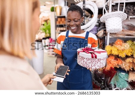 Florist accepting payment using NFC technology on smartphone in flower shop